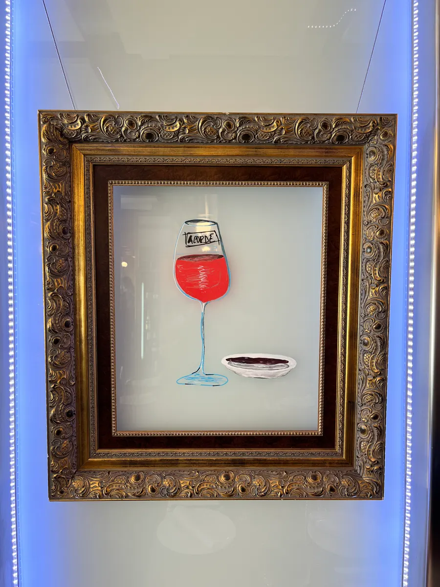 Cuadro de una copa de vino en la pared de Cervecería Acorde