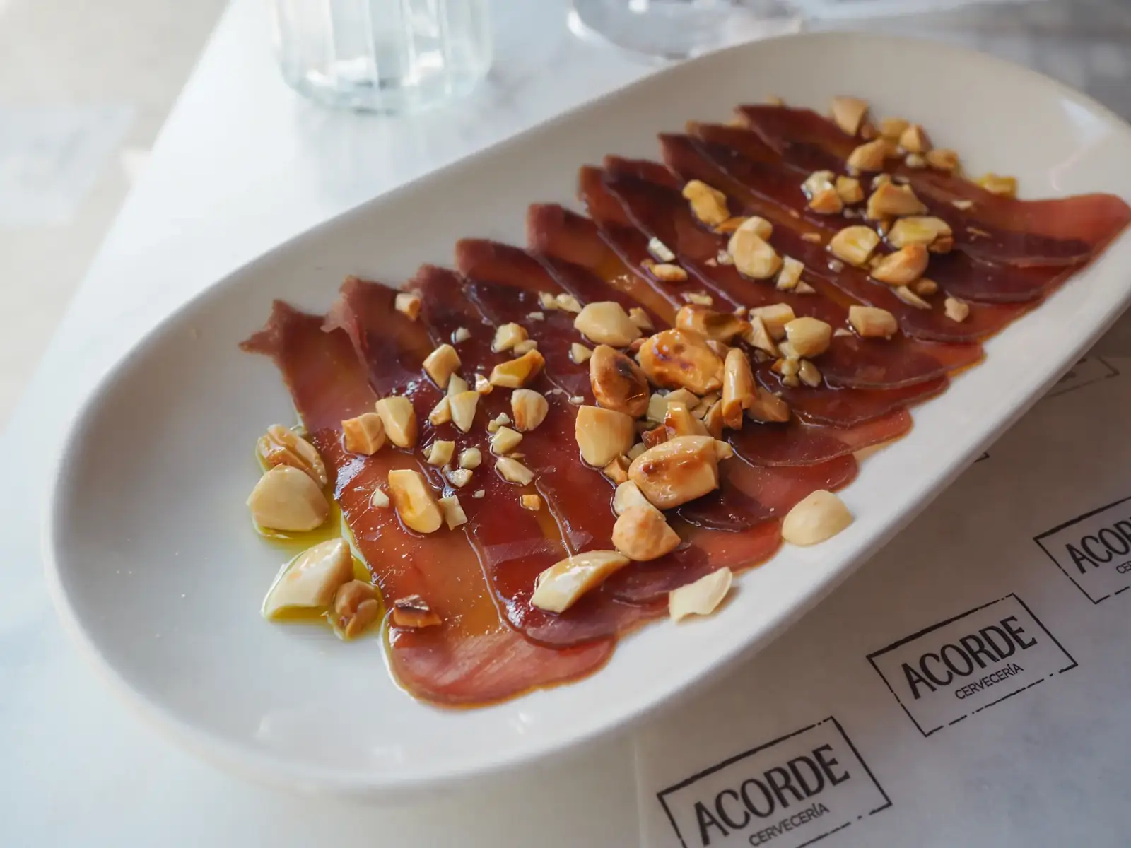 Plato de mojama con almendras servido en Cervecería Acorde